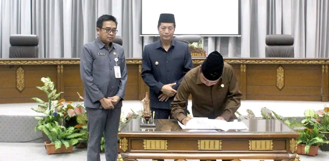 Pj Bupati Barito Utara Drs Muhlis didampingi Asisten Sekda Eveready Noor menyerahkan materi raperda untuk dibahas bersama dalam rapat gabungan komisi